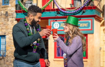 Two friends with drinks during Mardi Gras