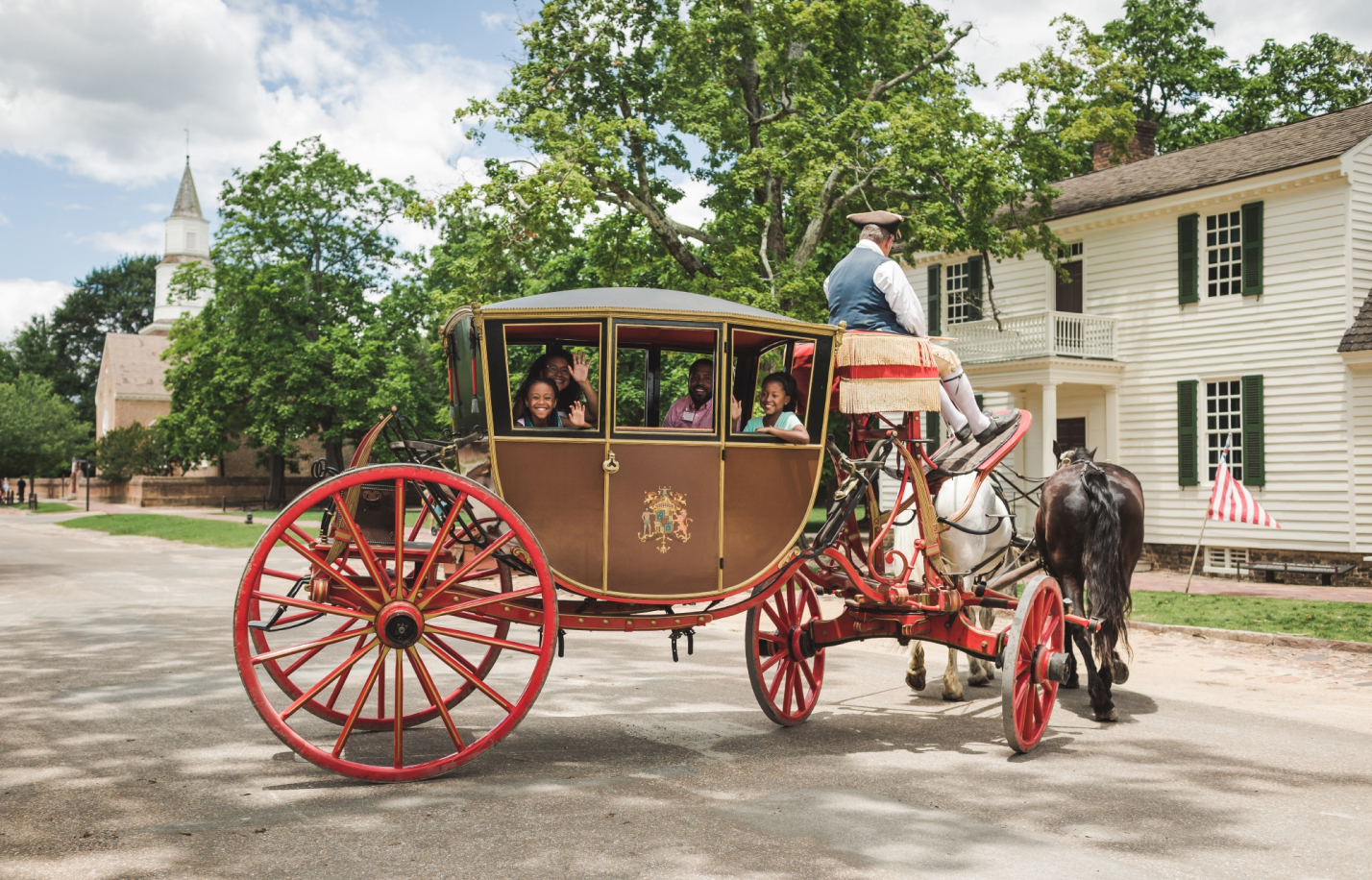 Family in a horse drawn carriage in colonial Williamsburg